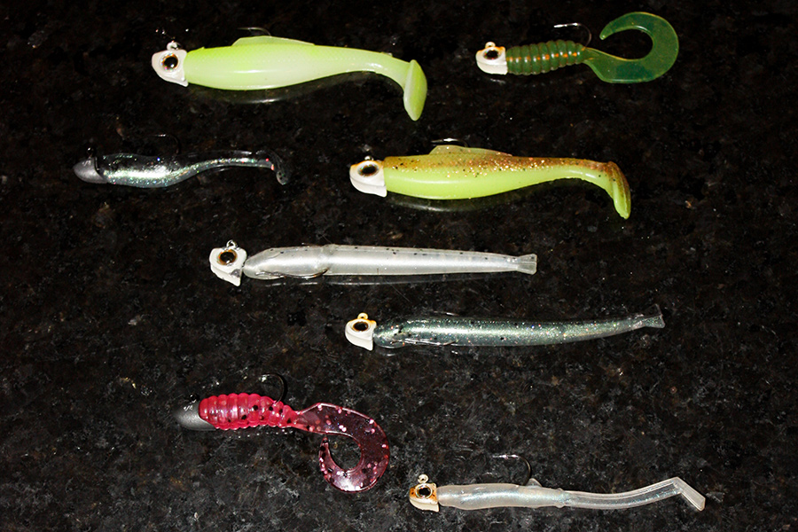 A selection of Berkley (unpainted) and Z-Man jig-heads armed with 2.5-3” soft-plastic tails. Note how the longer, narrower TRD MinnowZ (middle rows) are hooked differently, with the hook point exiting the ‘chin’ and being reinserted through the entire body further down, leaving the shank to run along the soft-bait’s belly.